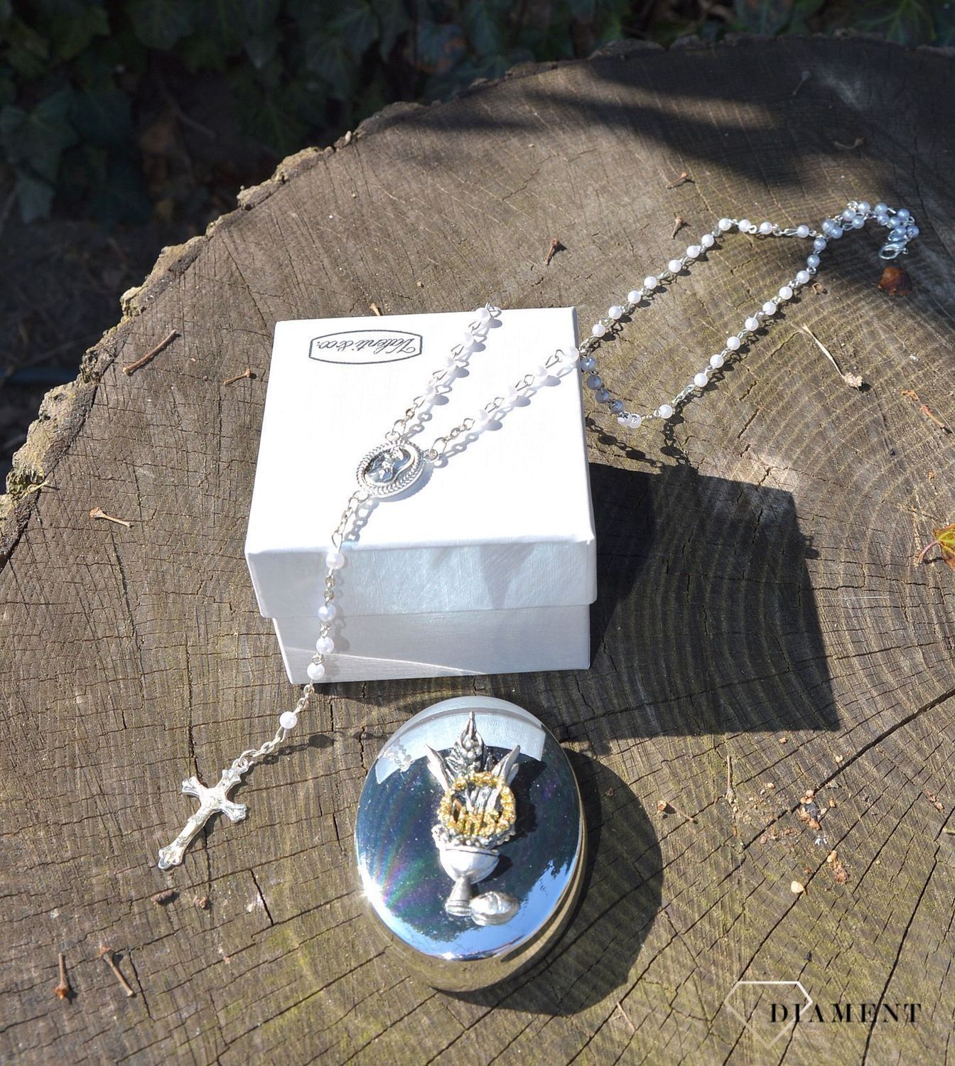 Różaniec komunijny z koralików w kolorze perłowym w pięknym, ozdobnym posrebrzanym opakowaniu. Komunia Św. to 4 symbole różaniec, książeczka, medalik oraz świeca (1).JPG